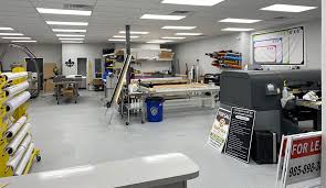 Sign and print shop with wide-format printer and materials.